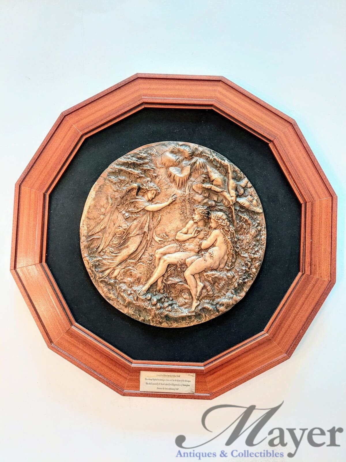 The central medallion of the Milton Shield, Adam and Eve and the angel Raphael.