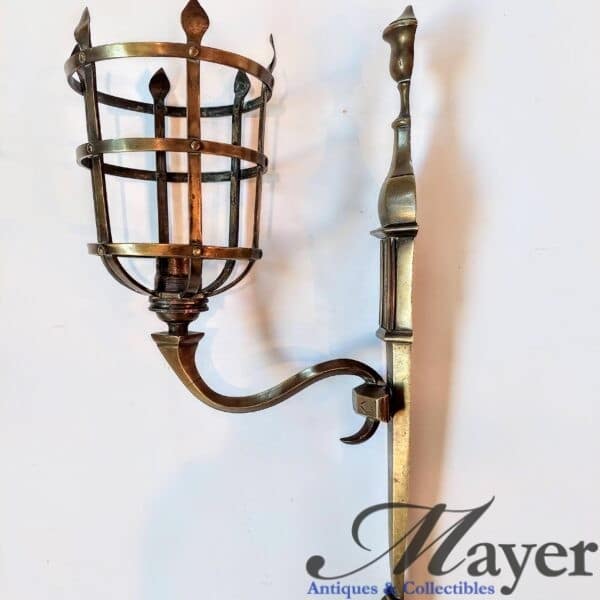 A medieval style light fixture with elaborate cage made of bronze.